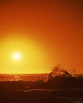 Sunset over the Indian Ocean, with waves breaking on coastline of Prevwlly