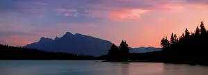 Alberta Prints: Sunset over Jack Lake and Rocky Mountains with trees visible along the shoreline near Banff