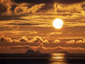 Polar Climate Prints: Sunset on a large iceberg at sea towards Peter I Island