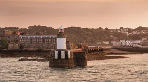 Channel Prints: Sunset light bathing the lighthouse and Castle Cornet at the entrance to St