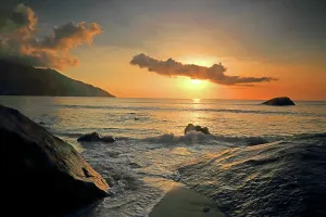 Retreat Prints: Sunset over the ocean at Beau Vallon Beach with rocks near the shore in Seychelles