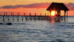 Retreat Prints: Sunset over the pier creating a vibrant scene with the sun setting behind the structure and reflecting in the water