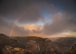 Kauai Prints: Sunset rainbow arches over the Waimea Canyon and Waipo o Falls towards the moon