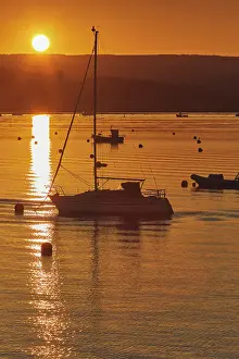 Watercraft Prints: Sunset over the River Exe estuary with boats in the water reflecting sunlight