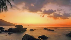 Relaxing Prints: Sunset over rocks and sea at Beau Vallon beach on Mahe island in Seychelles