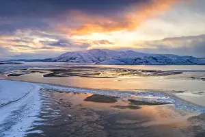 Snowcapped Prints: Sunset over the snow capped mountains and frozen sea in the pristine Tanamunningen Nature