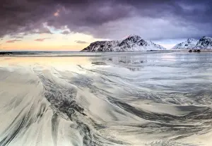 Sunset on the surreal Skagsanden beach surrounded by snow covered mountains, Flakstad