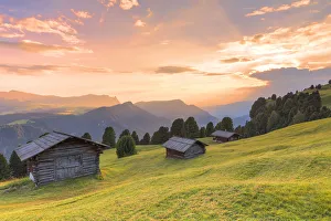 Huts Prints: Sunset above traditional huts in the pasture
