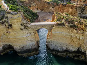 Algarve Prints: Sunset view of beach cliffs in Algarve with natural arch located near the shore