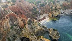 Earth Prints: Sunset view of beach cliffs by the sea in Algarve Portugal with rocky formations and calm water