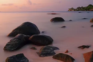 Retreat Prints: Sunset view over calm water and rocky shore at Beau Vallon Beach in Seychelles during evening hours