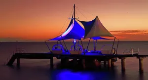 Nightlife Prints: Sunset view at Coco de Mer hotel in Praslin Seychelles with colorful lights on the pier