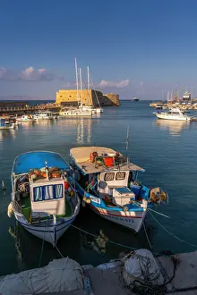 Fishermen Prints: Sunset view of Koules Venetian Fortress with boats in Heraklion Venetian Port near the city