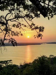 Silhouettes Prints: Sunset view over Lake Peten Itza from Mirador Rey Canek in Guatemala with trees framing the scene