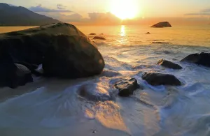 Azure Prints: Sunset over the water at Beau Vallon Beach in Seychelles with rocks and waves at dusk