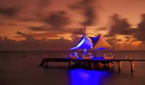 Brightness Prints: Sunset over water with light fixtures at Coco de Mer resort on Praslin Island in Seychelles