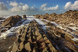 Surf rolling onto a rocky Atlantic shore, at Widemouth Bay, near Bude, Cornwall
