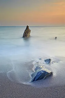 Kingsbridge Prints: Surf rolls around shoreline rocks at sunset