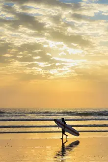 Surfboard Prints: Surfer with long board at sunset on popular Playa Guiones surf beach