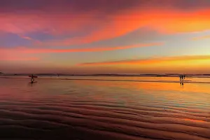 Adults Prints: Surfer silhouetted on Guiones Beach where many come to relax and surf at sunset