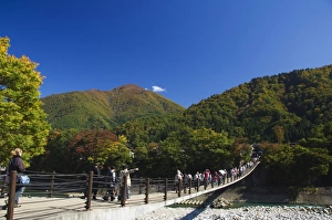Gifu Prints: Suspension bridge with tourists looking at autumn colours