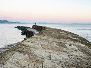 Photographer Prints: Taking a photograph at the end of The Cobb at sunset