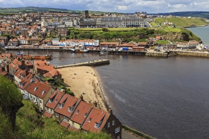 Tate Hill Beach, red roofed houses, town on West Cliff with backdrop of green hills in summer