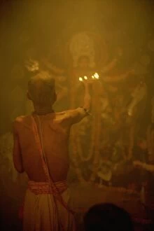 Temple priest before the image of the ten armed warrior goddess Durga, Durga Puja Festival