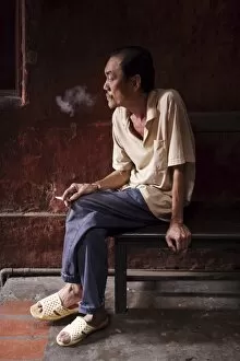 Temple worker smoking, Ho Chi Minh City (Saigon), Vietnam, Indochina, Southeast Asia