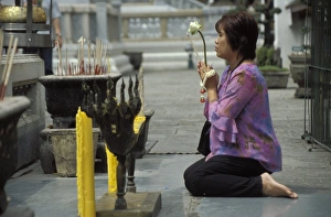 Worshipping Prints: Thai Buddhist woman praying at temple