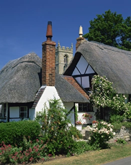 Thatched cottages, with the village church behind, at Welford on Avon in Warwickshire
