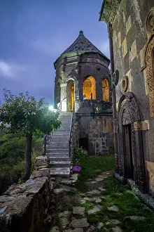 Small Prints: Tiri monastery stands on a hillside with a stone staircase leading to a lit entrance in the evening in South Ossetia