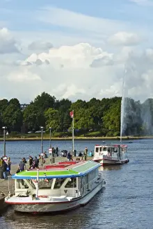 Hamburg Prints: Tour boats that ply Alster Lake moored at the Jungfernstieg with the Lombardsbruecke beyond