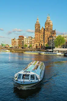 Tourist boat and Basilica of Saint Nicholas, Amsterdam, The Netherlands, Europe