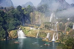 Tourist boats beneath Detian Falls, China and Vietnam transnational waterfall
