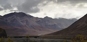 Tourist bus driving among mountains in the Denali National Park, Alaska, United States of America