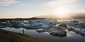 Tourist at Jokulsarlon Glacier Lagoon at sunset, South East Iceland, Iceland, Polar