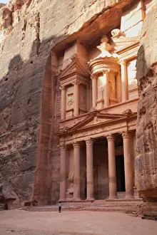 Classical Style Prints: Tourist looking up at the facade of the Treasury (Al Khazneh) carved into the red rock at Petra