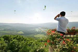 Motovun Prints: A tourist photographs paragliders from atop the hilltop village of Motovun