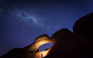 Namibian Prints: Tourist under the Rock Arch bridge in the Spitzkoppe region with a view of the Milky Way