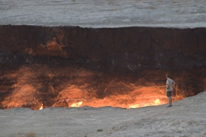 Images Dated 5th August 2009: Tourist standing on the edge of the Darvaza Gas crater, Turkmenistan, Central Asia, Asia