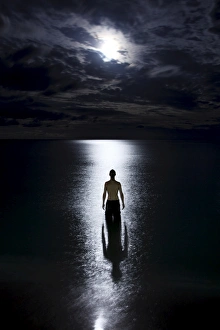 Tourist standing in the ocean watching the moon rise on Haad Rin Nai beach Tourist standing in the ocean watching the moon rise on Haad Rin Nai beach