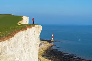 Lighthouses Prints: Tourist stands on top of the cliff overlooking Beachy Head lighthouse