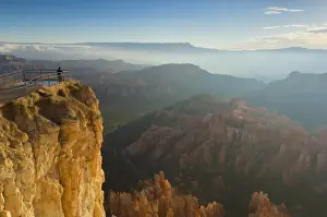 Hoodoos Prints: Tourist watching the sunrise with low mist over the sandstone hoodoos in Bryce Amphitheater