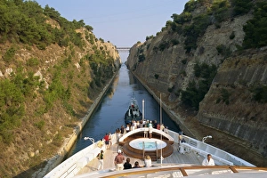 Tourists on the bow of a ship being pulled by tug through