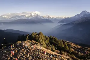 Tourists gather on Poon Hill to watch the sunrise over the Annapurna Himal, with Dhaulagiri, 8167m, Dhampus Peak, 6012m, and Tukuche Peak, 6920m and Nilgiri, 7061m, visible in the background, Annapurna Conservation Area, Nepal, Himalayas, Asia