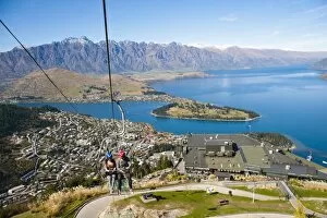 Images Dated 8th April 2011: Two tourists on the gondola to the luge track above Queenstown, Otago, South Island, New Zealand