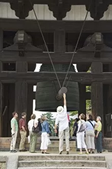 Tourists look at big cast iron bell