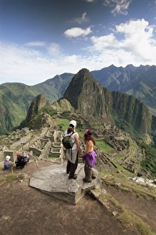 Machu Picchu Prints: Tourists looking out over the ruins of the Inca site