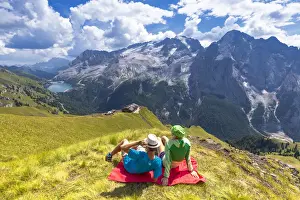 The Great Outdoors Prints: Tourists looks Viel del Pan Refuge with Marmolada in the background. Pordoi Pass